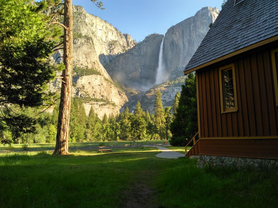 Yosemite National Park - Yosemite Chapel con las cascadas Yosemite Falls al fondo.