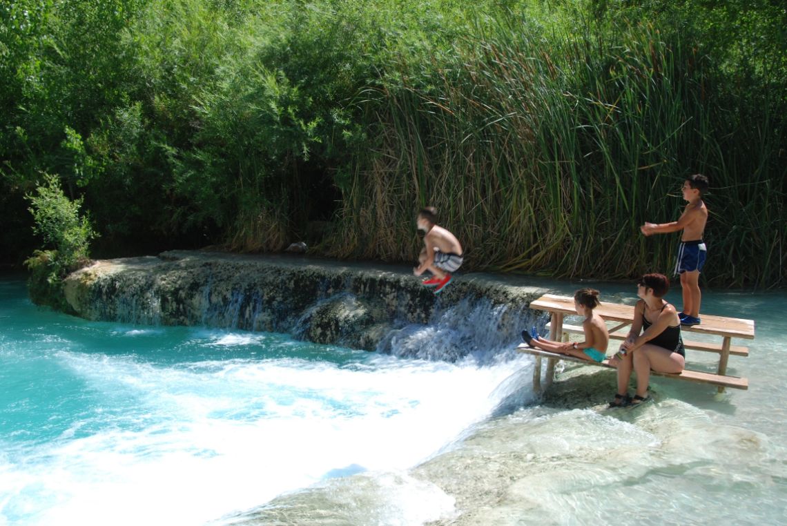 Havasupai - Disfrutando en las piscinas naturales después de las cascadas Havasu Falls. Niños saltando desde un banco.
