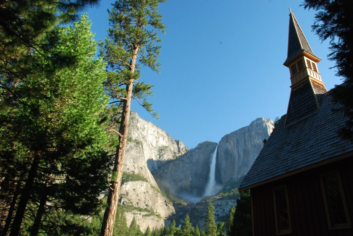 Yosemite Valley - Yosemite chappel o capilla de Yosemite situada cerca del Swinging bridge. Las cascadas de Yosemite Falls están al fondo.